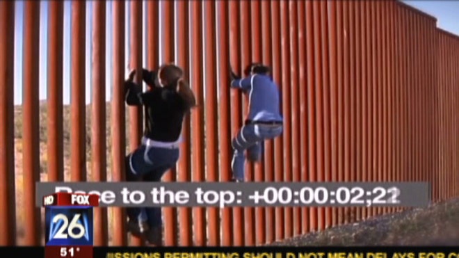 women climbing border fence